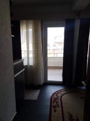 a room with a large window and a bed and a door at Apartmani Ambiente in Plav