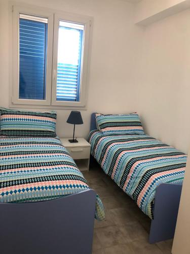two beds sitting next to each other in a bedroom at Appartamenti San Lorenzo Marzamemi Cecilia in San Lorenzo