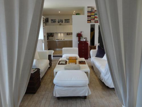 a living room with white furniture and white curtains at Nerone's - Sutri Bed & Dinner in Sutri