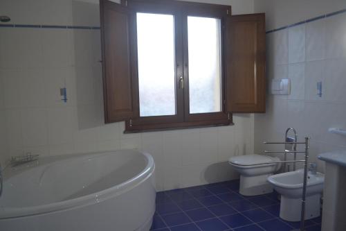 a bathroom with a tub and a toilet and a sink at Sinis my love in Càbras