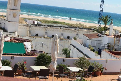 
a beach with a beach house and a large building at Almadraba Conil in Conil de la Frontera
