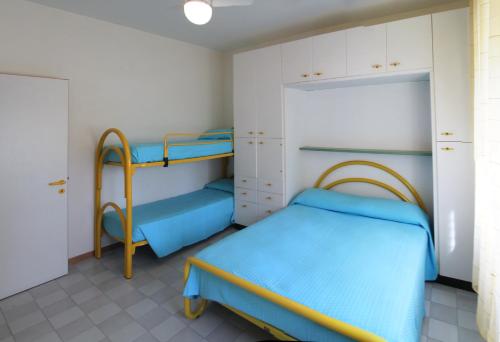 リド・ディ・イエゾロにあるVilla Ongaroの二段ベッド2台とクローゼットが備わる客室です。