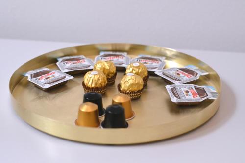 een gouden plaat met gouden en zilveren cupcakes erop bij BpR Auric Home in Boedapest