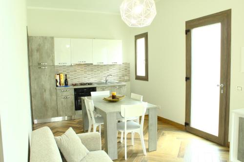 a kitchen and dining room with a white table and chairs at Suite Capaci in Capaci