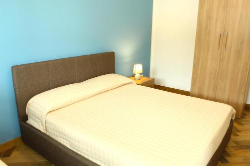 a bed in a bedroom with a blue wall at Suite Capaci in Capaci