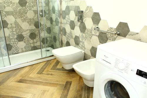 a bathroom with a toilet and a washing machine at Suite Capaci in Capaci