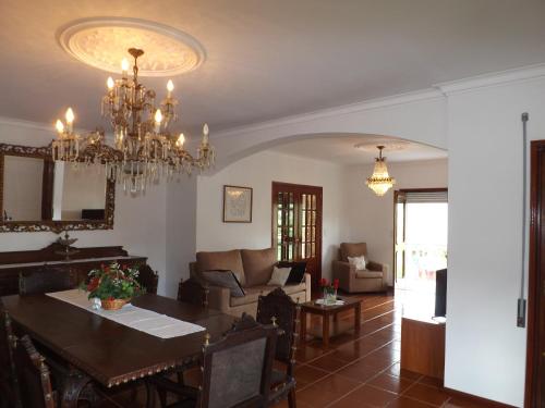 a dining room and living room with a chandelier at Casa Oliveira in Grovelas