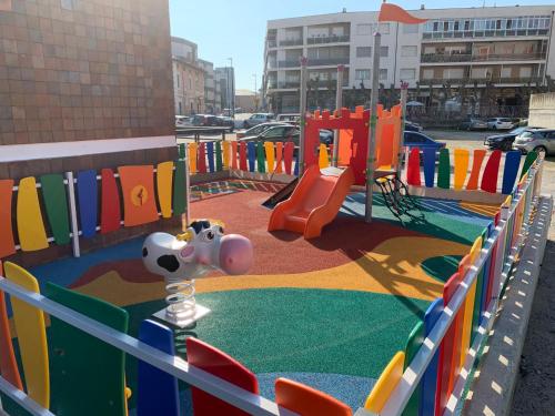 a playground in a parking lot with a play equipment at Montemar in Llanes