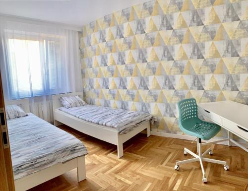 Cette chambre comprend deux lits, un bureau et une chaise. dans l'établissement D&M Apart Interior Styles, à Białystok