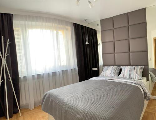 - une chambre avec un grand lit et une fenêtre dans l'établissement D&M Apart Interior Styles, à Białystok