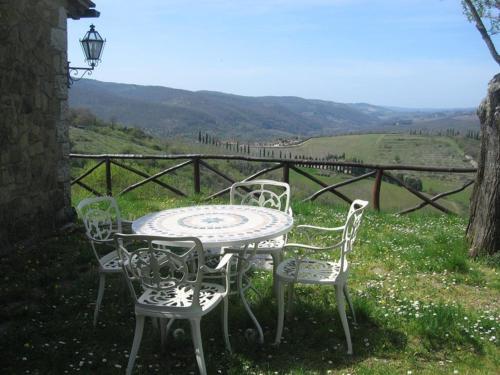 a table and chairs with a view of a field at Camere e Appartamenti Baldini Romanita in Radda in Chianti