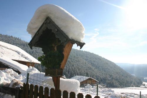 a wooden fence with snow on top of it at Panoramapension Etschblick in Meltina