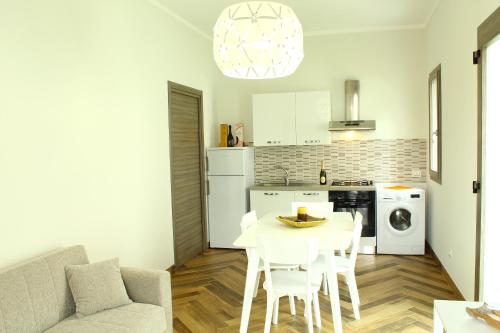 a living room with a table and a kitchen at Suite Capaci in Capaci