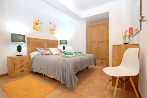 ガンディアにあるApartamento Beti SOLO FAMILIASのベッドルーム1室(ベッド1台、白い椅子付)