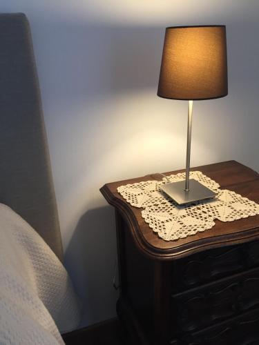 a lamp on a table next to a bed at Cascina Delle Rose in Barbaresco