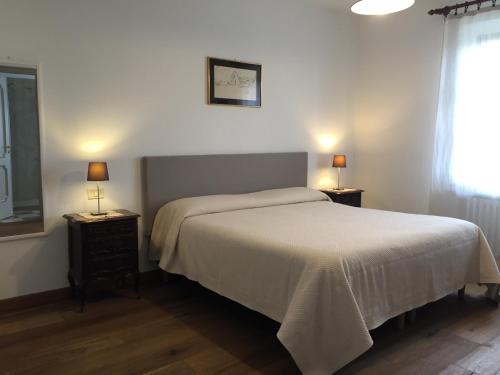 a bedroom with a bed and two lamps on tables at Cascina Delle Rose in Barbaresco