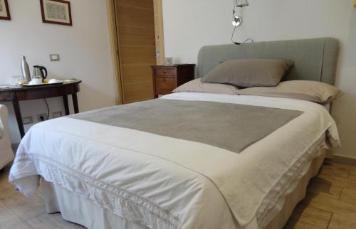 a large bed in a bedroom with a table at Nerone's - Sutri Bed & Dinner in Sutri