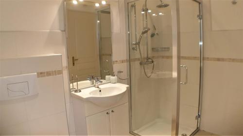 une salle de bain avec un lavabo et une douche dans l'établissement Les Lavandes, à Étaules