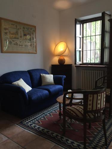 a living room with a blue couch and a chair at Cascina Delle Rose in Barbaresco