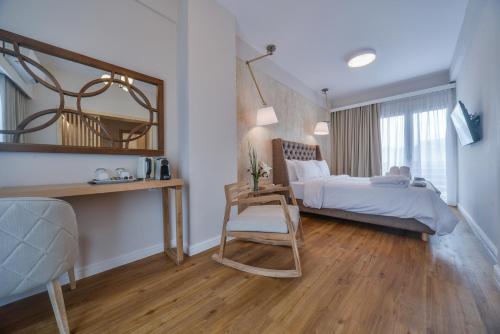 a bedroom with a bed and a chair and a mirror at A.P. Acropolis View Apartments in Athens