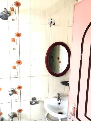 a bathroom with a mirror and a sink at Tirupati Lodge NJP in Siliguri