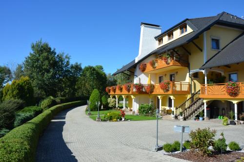 a large yellow building with flower boxes on the balconies at Frühstückspension Porranzl in Hofamt Priel