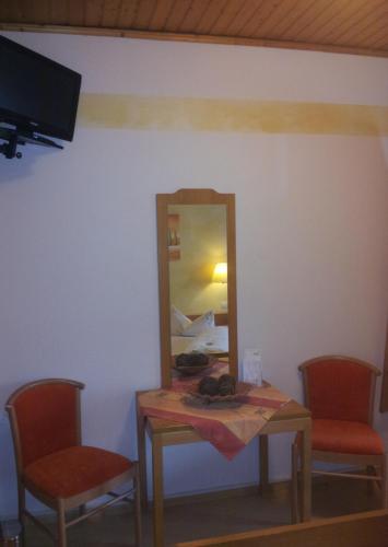 a table in a room with two chairs and a mirror at Hotel - Restaurant Hirschen - Werneths Landgasthof beim Europa- Park Rust in Rheinhausen