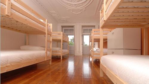 a room with four bunk beds in a room with a ceiling at So Cool Hostel Porto in Porto