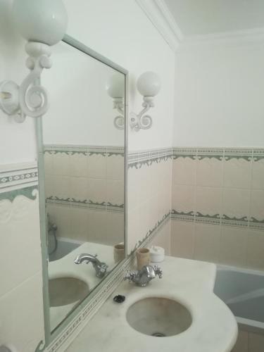 a bathroom with a mirror and a sink at Studio le Memagne in Lacuisine