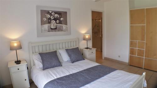 une chambre avec un lit avec deux tables de nuit et deux lampes dans l'établissement Les Lavandes, à Étaules