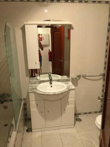 un baño con lavabo y ducha en Acropole Algarve Beach Apartment, en Portimão