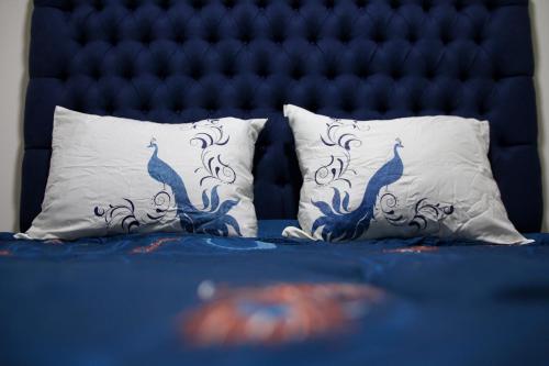two pillows on a bed with a blue head board at Departamento Centrico Guadalajara in Guadalajara