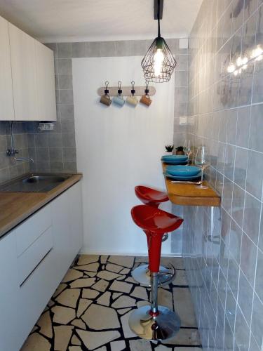a kitchen with a red stool and a counter at Apartmani Paulo in Vis