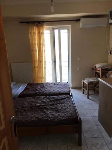 a bedroom with a bed and a window at Nonika’s house 1 in Tsoukalades