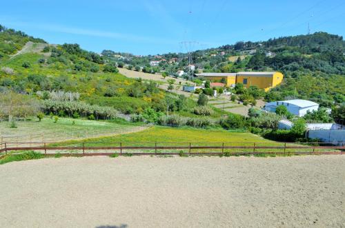 a view of a hill with a house on it at Horse Riding Country House in Vila Franca de Xira