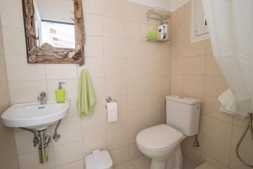 a bathroom with a toilet and a sink at Cavos Seaside House in Vathi, Ithaka