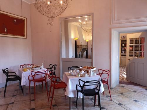 a dining room with two tables and chairs and a mirror at Bastide de Ganay - Saint Jérôme in Aix-en-Provence