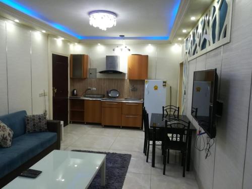 カイロにあるApartment at Milsa Nasr City, Building No. 36のリビングルーム(ソファ、テーブル付)、キッチンが備わります。