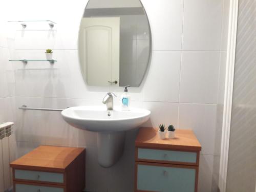 a white bathroom with a sink and a mirror at Cal Richi in Tremp