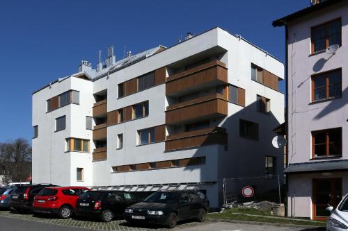 a white building with cars parked in front of it at Apartment Klostermann 006 in Železná Ruda