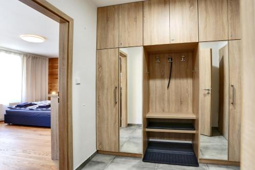 a locker room with wooden cabinets and a bed at Apartment Klostermann 006 in Železná Ruda
