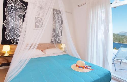 a bedroom with a blue bed with a hat on it at Petra Mare Village in Kerveli