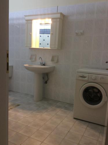 a bathroom with a washing machine and a sink at Anatoli View in Agia Marina Nea Kydonias
