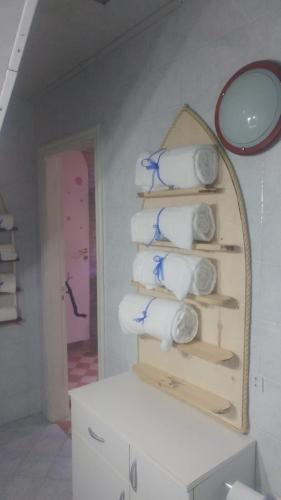 a bathroom with a mirror and a shelf with towels at Marinautica Sea Cottage in Sorrento