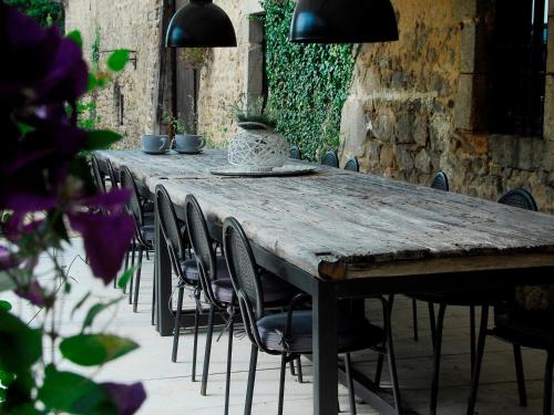 a long wooden table with chairs and plants on it at La Paresse en Douce in Tours-sur-Meymont
