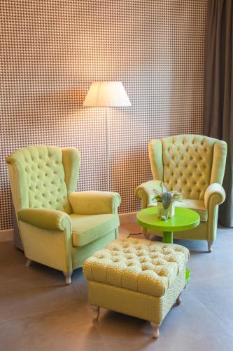 two chairs and a coffee table in a living room at Hotel Metropole in Grado