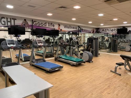 a gym with a bunch of treadmills and machines at Different Atmosphere Suite in Caesarea