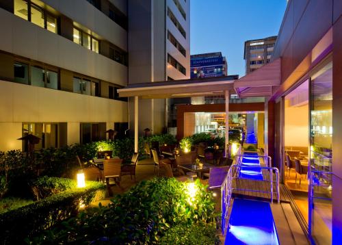 a hotel patio with tables and chairs and lights at Divan Istanbul City in Istanbul