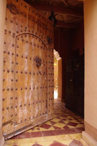 a large wooden door in a room with a tile floor at Kasbah La Cigogne in Aït Ben Haddou