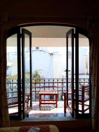 an open door to a patio with a table on a balcony at Hotel Virreynal in Córdoba